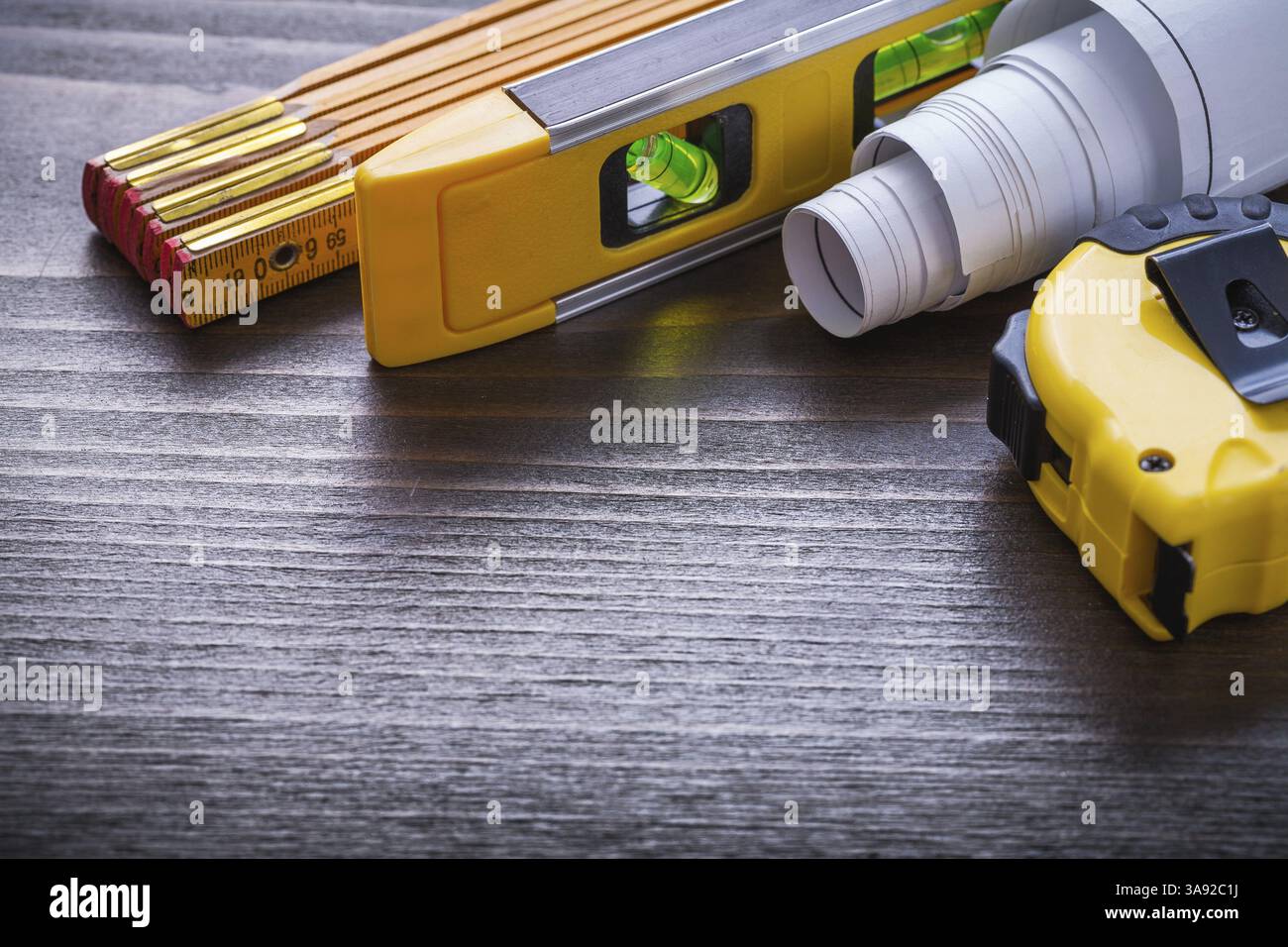 Ensemble de plans de ruban-mesure niveau de construction et mètre en bois sur le concept d'entretien de panneau de bois vintage Banque D'Images