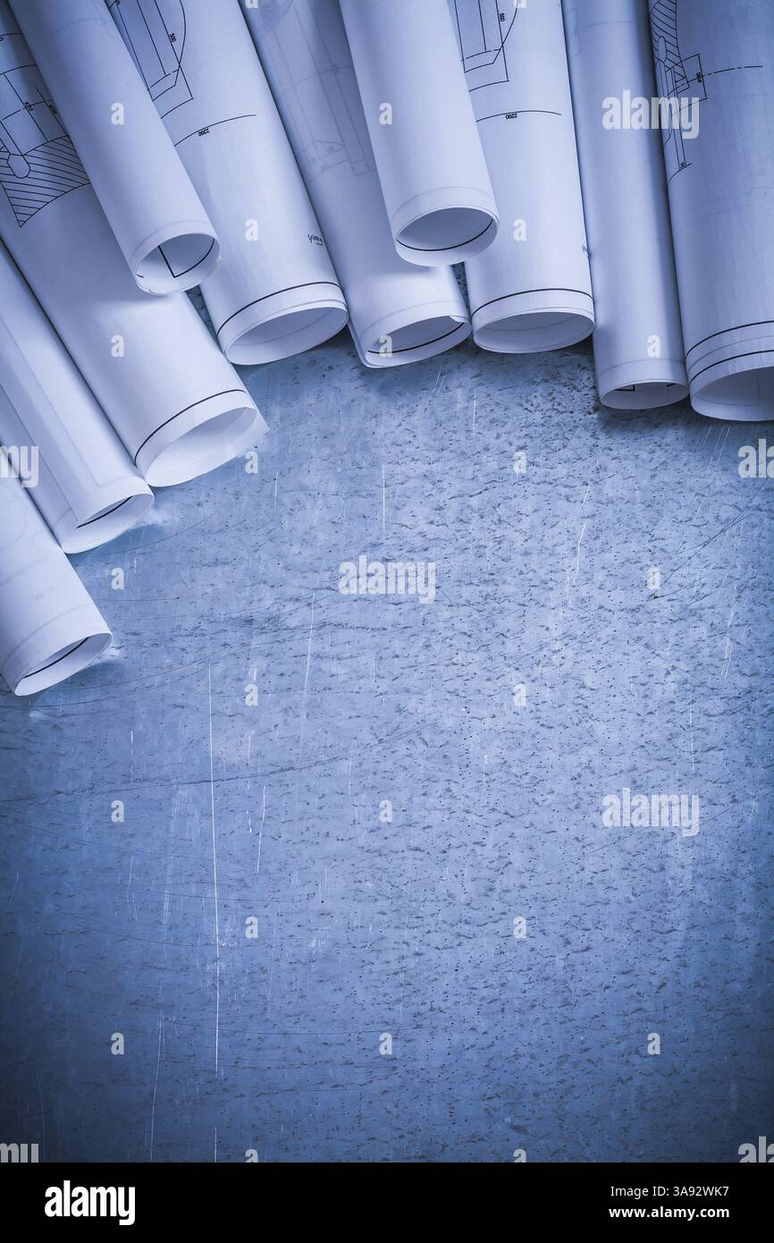 Variation des plans de construction blancs roulés sur le bâtiment à surface métallique argentée rayée et concept d'architecture Banque D'Images