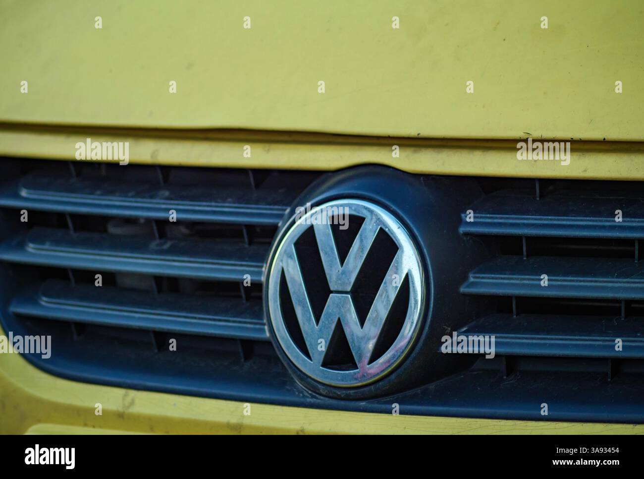 Gros plan détaillé du logo Volkswagen sur la calandre d'une vieille Volkswagen Polo, mettant en valeur le design vintage et l'aspect usé. Banque D'Images
