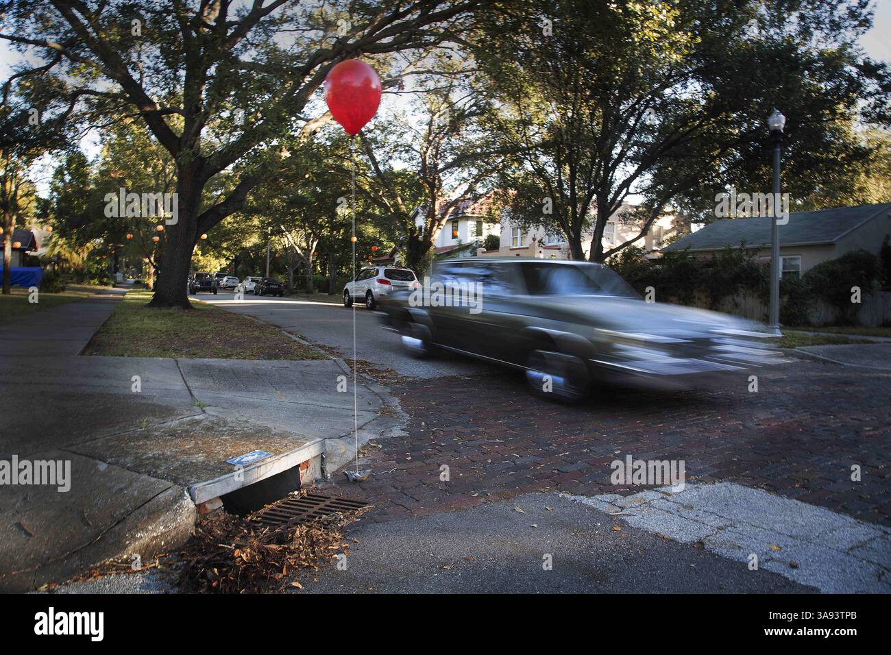 31 octobre 2017 - Petersburg, Florida, U.S. - SCOTT KEELER | Times. Des ballons rouges simples ont été placés à chaque égout pluvial dans le quartier de Crescent Lake Heights, à Petersburg, le mardi 10/31/17 pour Halloween. Le ballon rouge a été utilisé dans le nouveau film de l'auteur Stephen King IT Where un clown maléfique sort de sa cachette pour blesser des enfants dans la ville de Derry, dans le Maine. Le ballon signifie que le clown vous regarde. (Crédit image : © Scott Keeler/Tampa Bay Times via ZUMA Wire) Banque D'Images