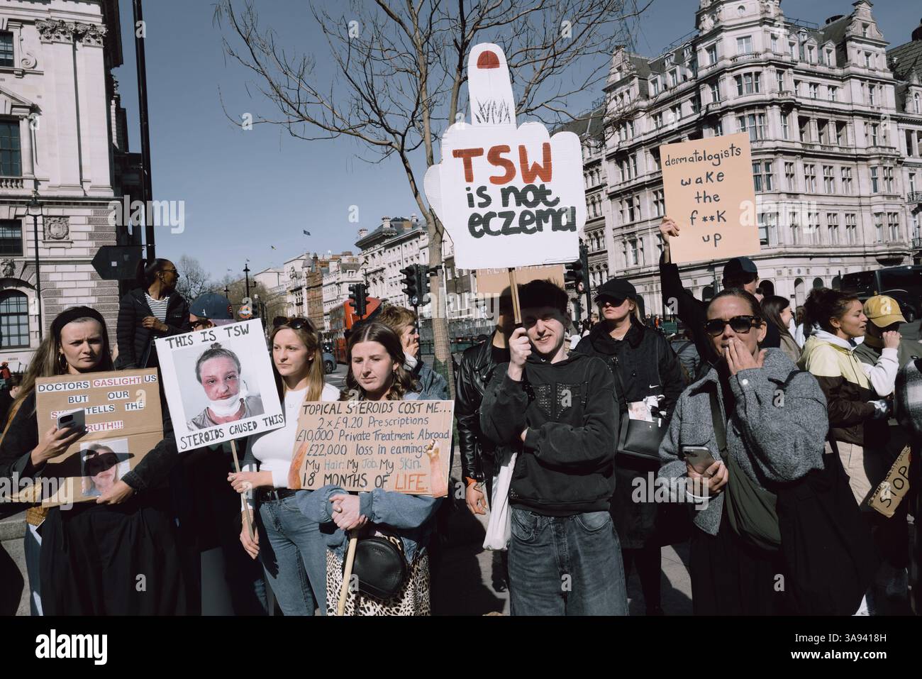 Londres, Royaume-Uni. 29 mars 2025. Un groupe de personnes touchées par le sevrage topique des stéroïdes (TSW) organise une manifestation à Parliament Square, Londres, exhortant le NHS à revoir ses protocoles de prescription des stéroïdes topiques. Les manifestants allèguent que le mauvais usage de ces traitements pour des affections comme l'eczéma a entraîné d'importantes souffrances chez les patients. Ils réclament une sensibilisation accrue et des lignes directrices plus strictes pour prévenir les effets indésirables associés à l'utilisation prolongée de stéroïdes. Crédit : Joao Daniel Pereira/Alamy Live News Banque D'Images