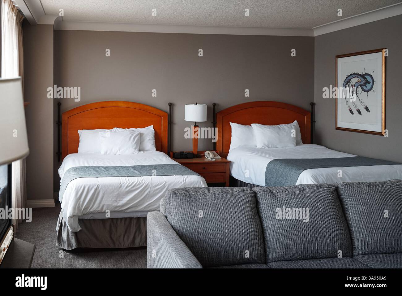 Un intérieur de la chambre d'hôtel du casino rama, avec deux lits simples, un canapé et une peinture avec des motifs indiens indiens décorant le mur. Banque D'Images