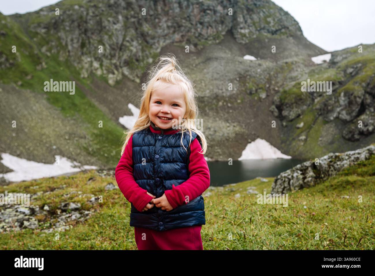 Enfant fille randonnée dans les montagnes vacances en famille voyage aventure de style de vie actif, portrait enfant de 3 ans heureux souriant en plein air Banque D'Images