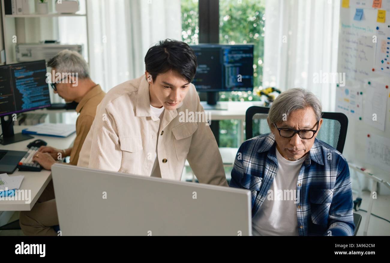 Groupe de senior asiatique dans un développement logiciel collaboratif analysant des organigrammes lors d'une formation bootcamp Banque D'Images