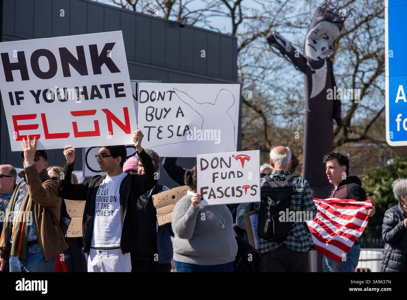 Londres, Royaume-Uni. 29 mars 2025. Manifestants avec leurs pancartes et drapeau devant le concessionnaire Tesla à Londres. Les militants de Tesla Takedown UK se sont rassemblés devant le concessionnaire Tesla pour participer à la Journée mondiale d'action à Londres. Les manifestants appellent au boycott contre la société de voitures électriques Tesla appartenant à Elon Musk. En raison de la récente implication milliardaire de la politique américaine et mondiale. Crédit : SOPA images Limited/Alamy Live News Banque D'Images