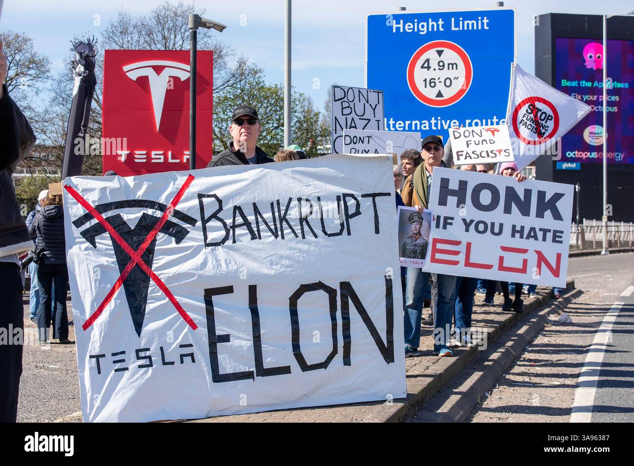Londres, Royaume-Uni. 29 mars 2025. Les manifestants se tiennent debout avec leurs panneaux près de l'autoroute devant le concessionnaire Tesla à Londres. Les militants de Tesla Takedown UK se sont rassemblés devant le concessionnaire Tesla pour participer à la Journée mondiale d'action à Londres. Les manifestants appellent au boycott contre la société de voitures électriques Tesla appartenant à Elon Musk. En raison de la récente implication milliardaire de la politique américaine et mondiale. Crédit : SOPA images Limited/Alamy Live News Banque D'Images