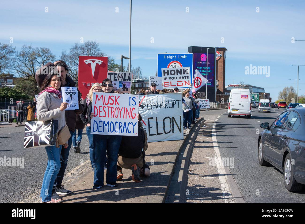 Londres, Royaume-Uni. 29 mars 2025. Les manifestants se tiennent debout avec leurs pancartes près de l'autoroute devant le concessionnaire Tesla à Londres. Les militants de Tesla Takedown UK se sont rassemblés devant le concessionnaire Tesla pour participer à la Journée mondiale d'action à Londres. Les manifestants appellent au boycott contre la société de voitures électriques Tesla appartenant à Elon Musk. En raison de la récente implication milliardaire de la politique américaine et mondiale. Crédit : SOPA images Limited/Alamy Live News Banque D'Images