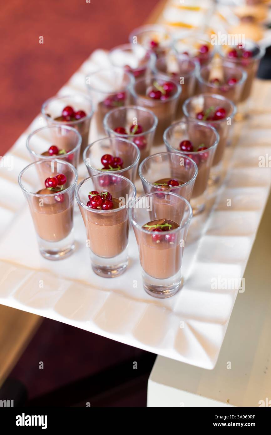 Un plateau de desserts dans de petits verres et sont surmontés de baies, prêts à être servis Banque D'Images