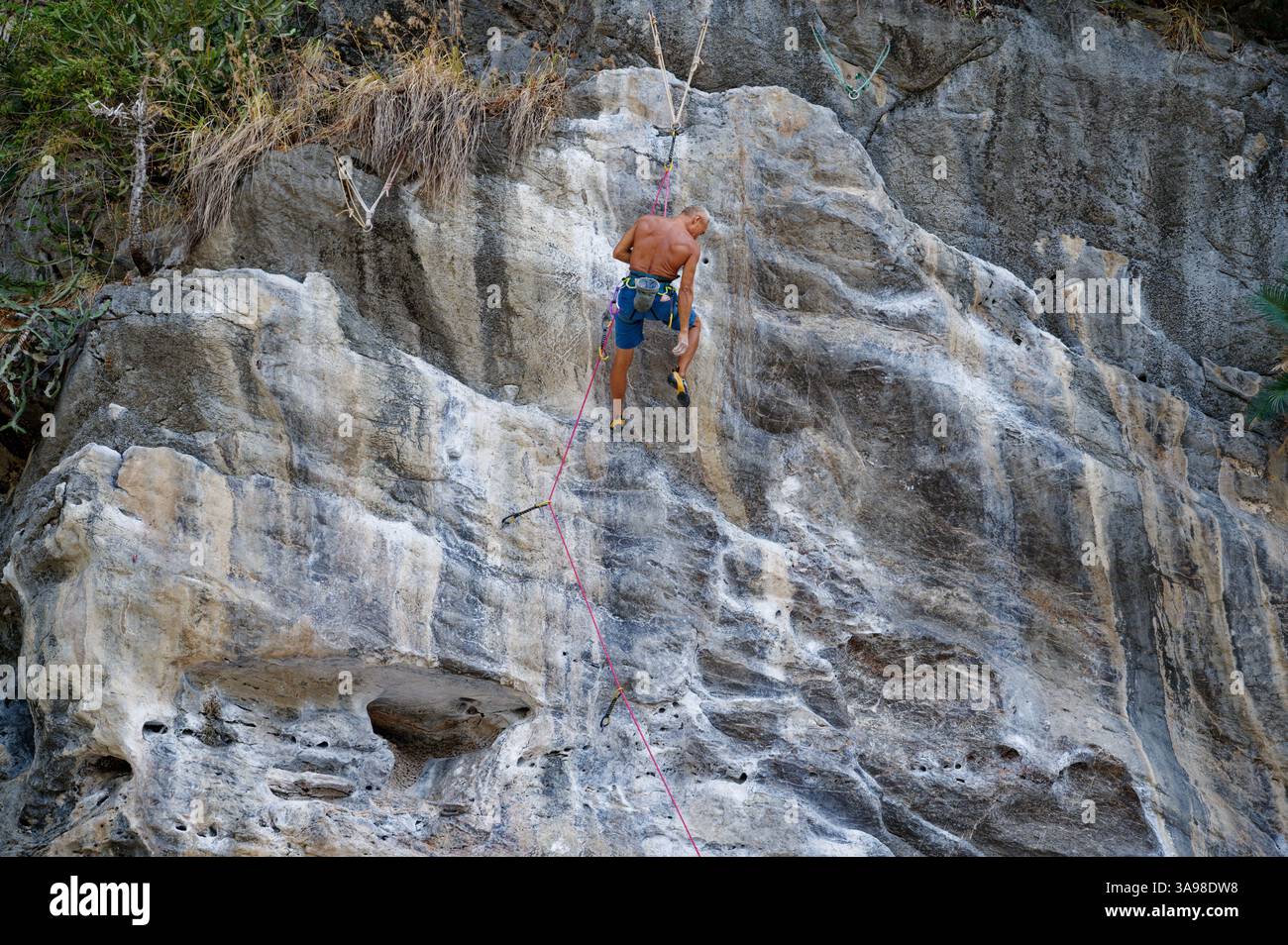 Un grimpeur expérimenté descend gracieusement un mur de calcaire Banque D'Images