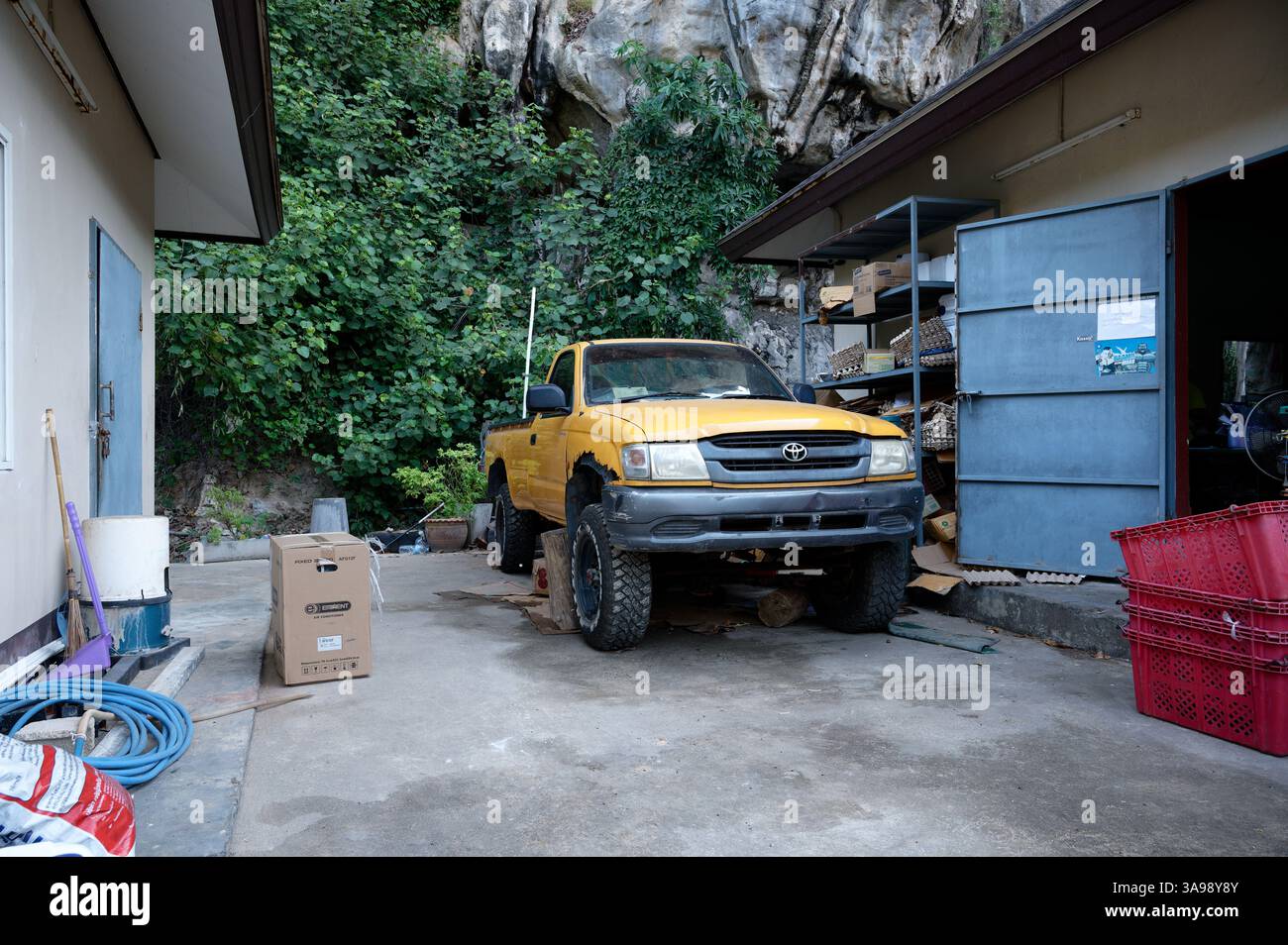Vintage jaune pick-up Toyota se trouve sur des blocs dans un coin d'atelier caché à Tonsai Banque D'Images