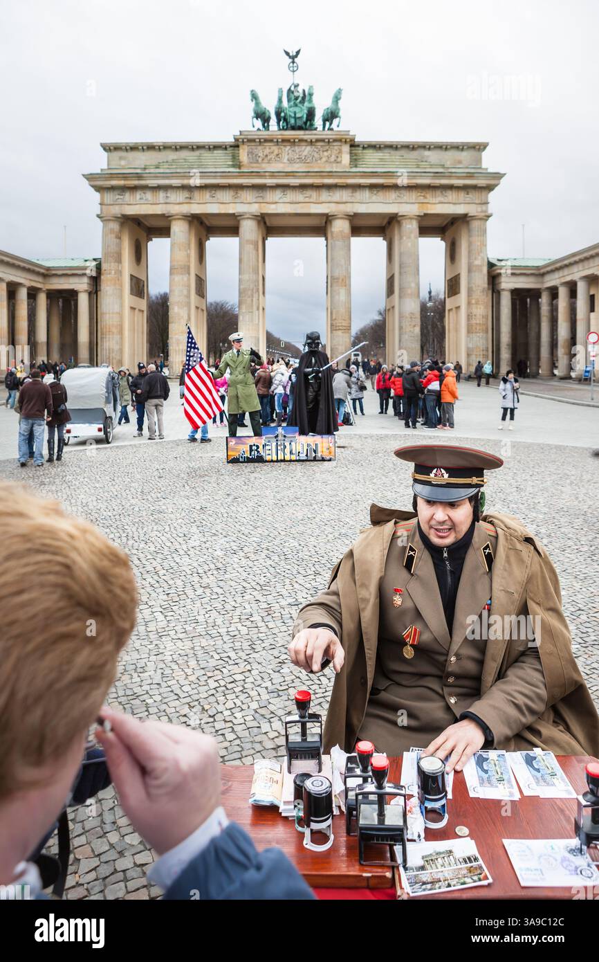 Berlin, ALLEMAGNE - 5 janvier 2012 : pièges à touristes / attractions à la porte de Brandebourg à Berlin. Un homme déguisé en officier russe tamponne des cartes Banque D'Images