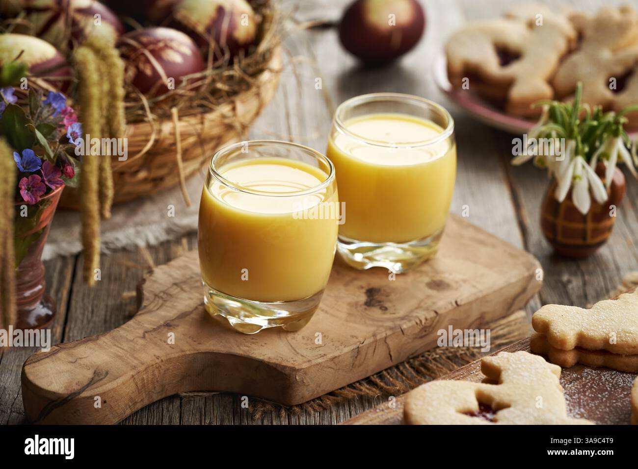 Deux verres d'Eiecognac avec décoration de Pâques, oeufs teints et fleurs printanières Banque D'Images