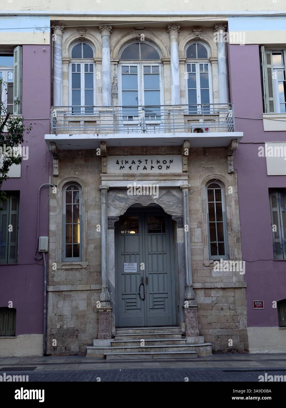La façade néoclassique du palais de justice d'Héraklion. Au-dessus de l'entrée, il est écrit en lettres grecques "salle judiciaire". La porte centrale en bois est accessible Banque D'Images