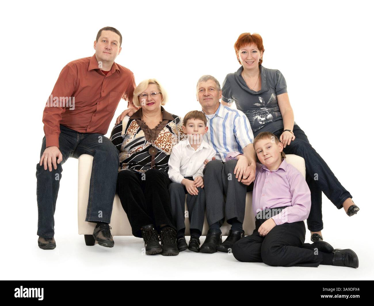 Trois générations d'une famille assise sur le canapé Banque D'Images