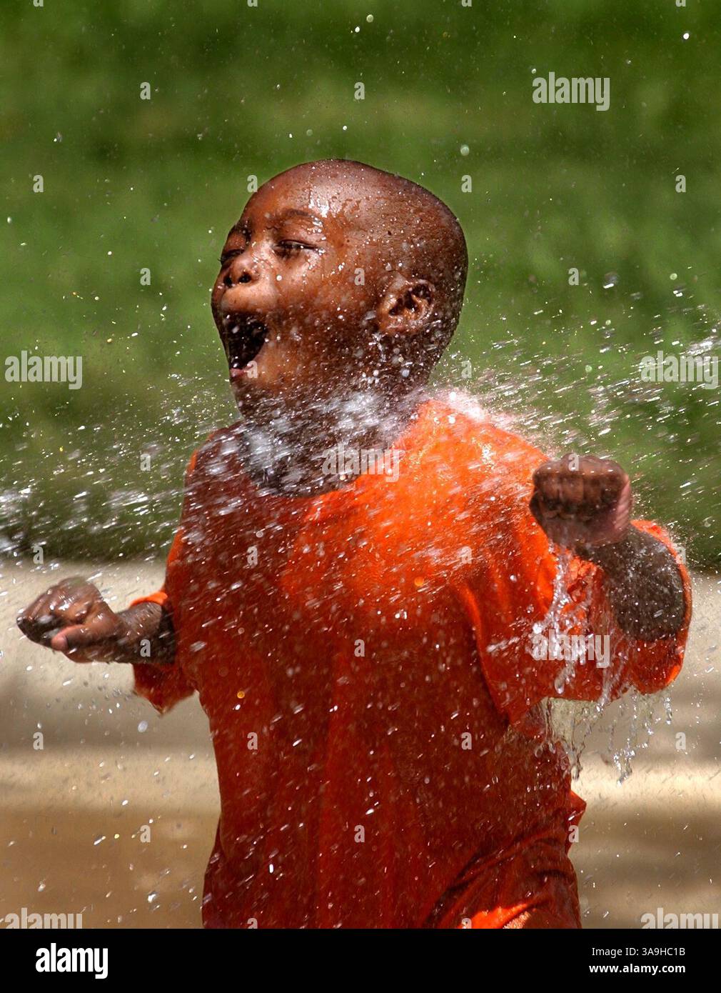 Deuxièmement - Duche Crozier, 5 ans, profite d'un souffle d'un tuyau de Pal Lealazaye Davis, 5 ans, au complexe immobilier New Helvetia près de Broadway et de la neuvième rue pendant la vague de chaleur de jeudi. The Sacramento Bee/ Anne Chadwick Williams / 17 juillet 2003 /ZUMA Press Banque D'Images