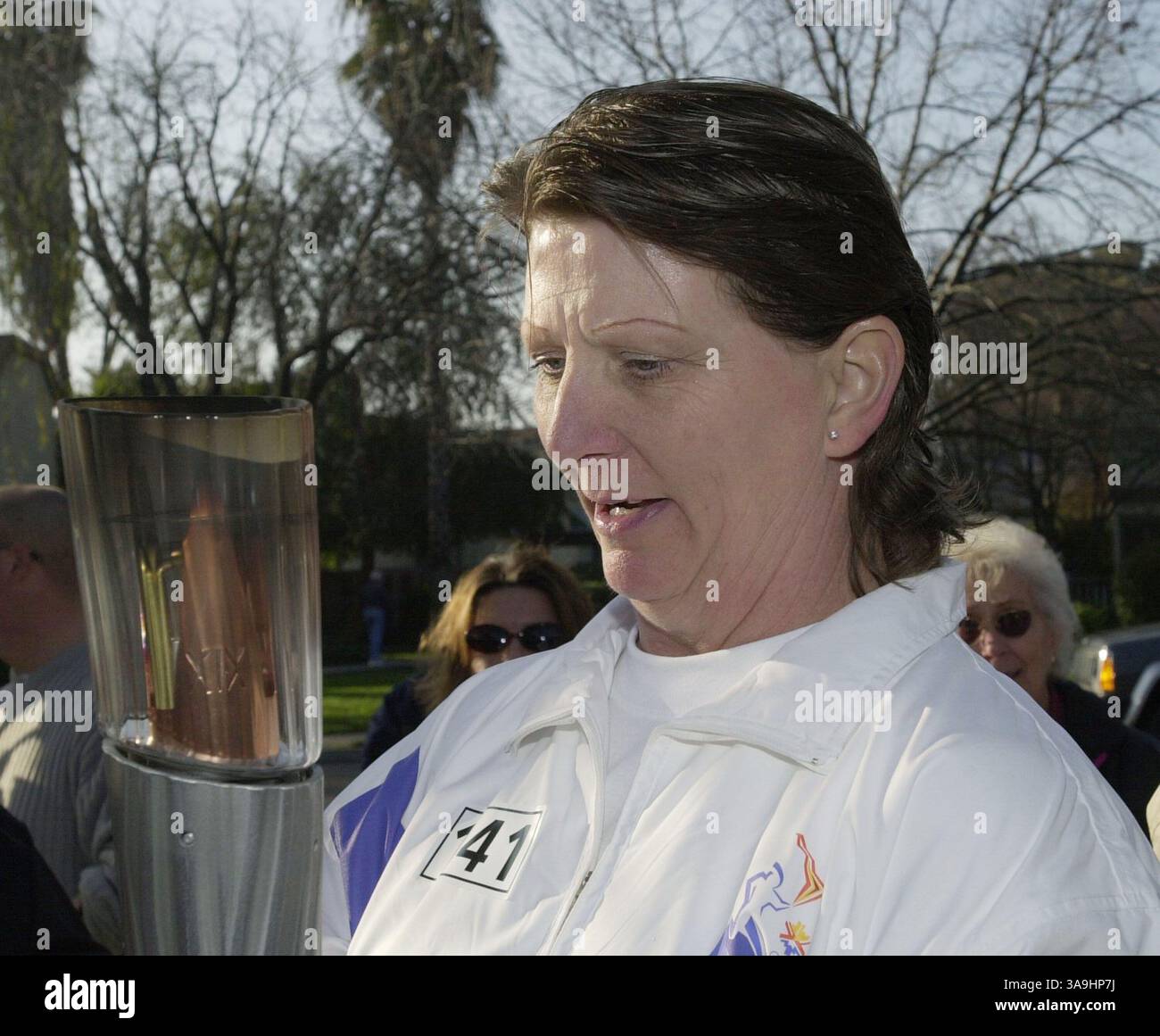 19 janvier 2002 ; Richmond, CA, États-Unis ; Melody Quintero, résidente d’Oakley, regarde la torche olympique après avoir terminé sa course à Concord, Calif, le samedi 19 janvier 2002. Quintero a été nominé pour l'honneur par sa fille. Banque D'Images