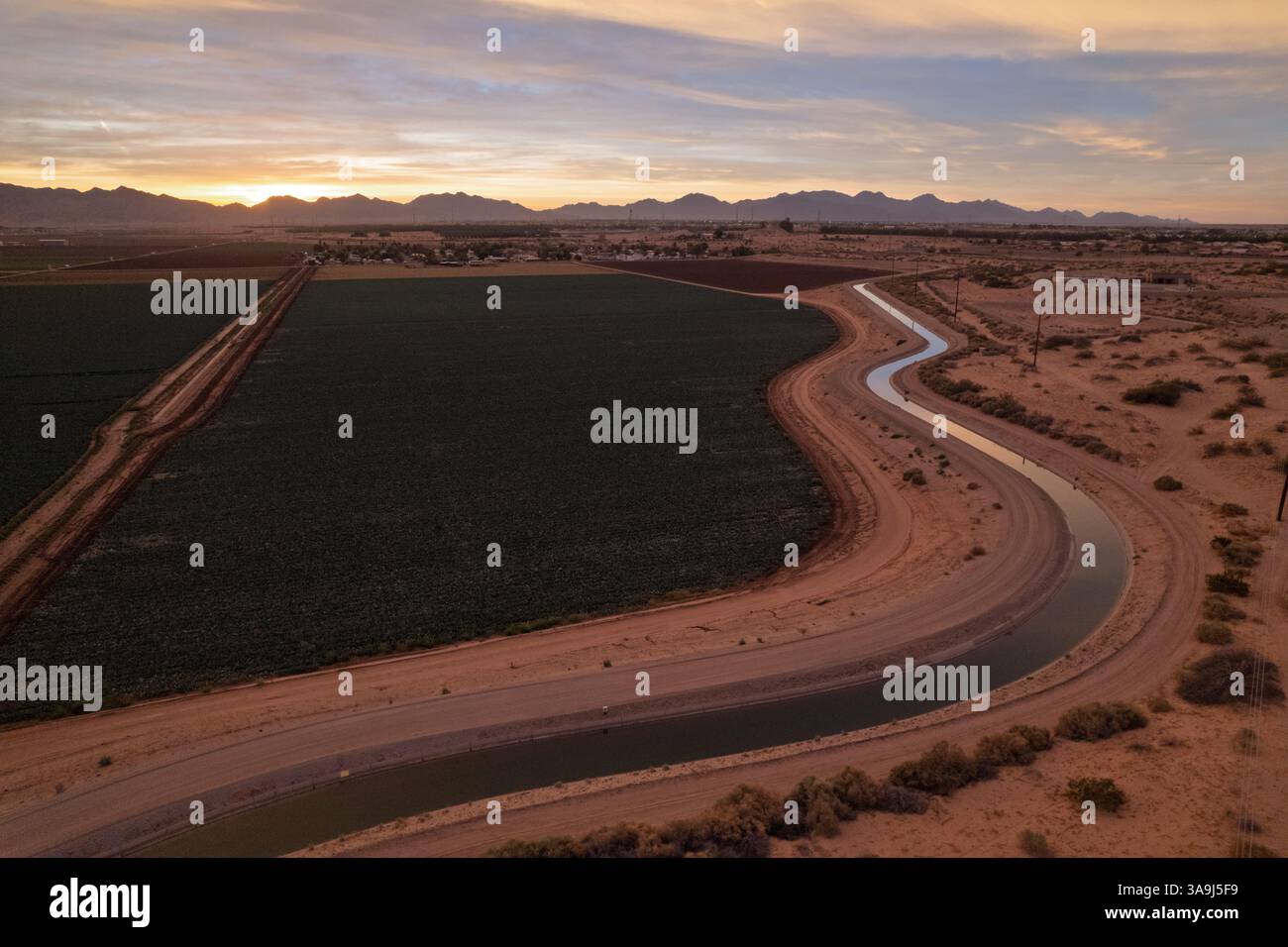 Vue aérienne des terres agricoles et du canal d'irrigation au lever du soleil près de Yuma, Arizona, montrant l'agriculture du désert et la lumière tôt le matin. Banque D'Images