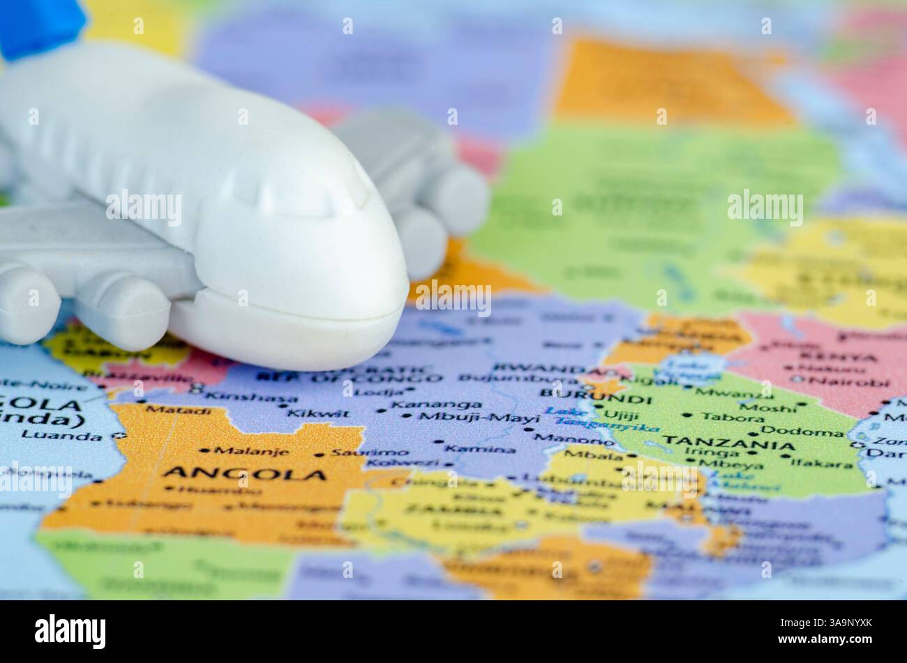 Gros plan d'un petit avion jouet placé sur une carte du monde représentant un voyage ou une exploration mondiale. Concept de voyage et de destination. Banque D'Images