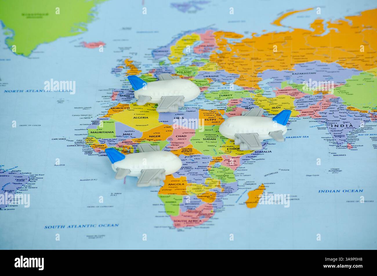 Vue de dessus de petits avions jouet placés sur une carte du monde représentant un voyage ou une exploration globale. Concept de voyage et de destination. Banque D'Images