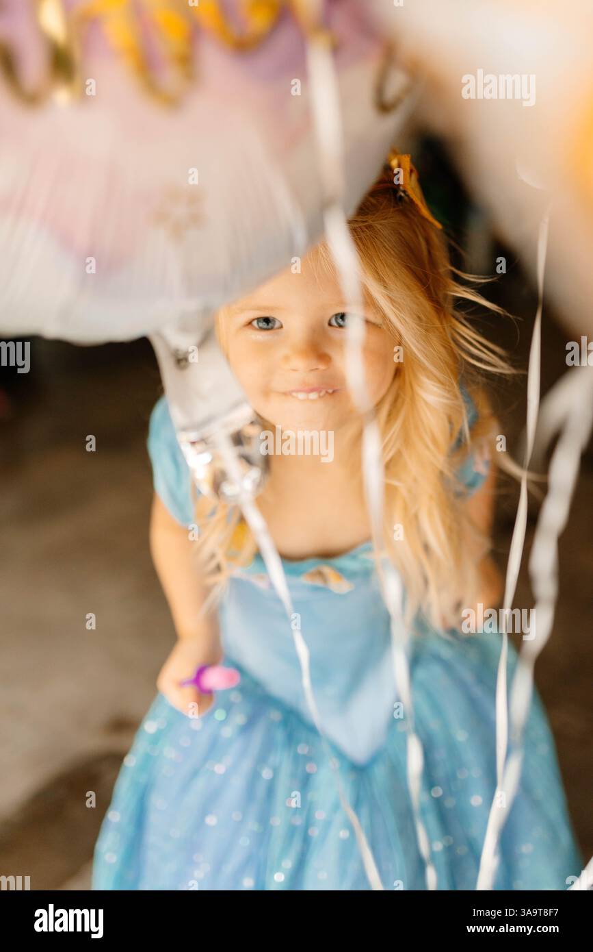 Fille d'anniversaire en robe de princesse avec des ballons Banque D'Images