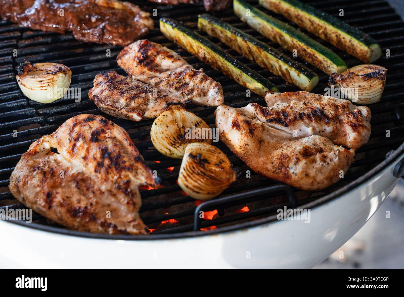 Poulet grillé et légumes sur charbons chauds Banque D'Images
