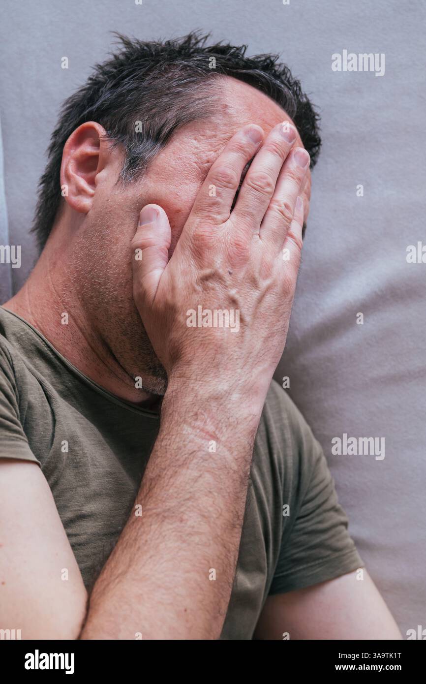 Vue en angle élevé d'un adulte adulte adulte pleurant sur un canapé-lit, mise au point sélective Banque D'Images