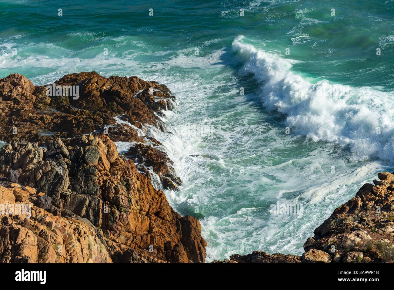 Vue aérienne des vagues de l'océan se brisant sur le rivage rocheux accidenté le long de Clarence Drive entre Gordons Bay et Rooi-Els près du Cap, Western Cape Banque D'Images
