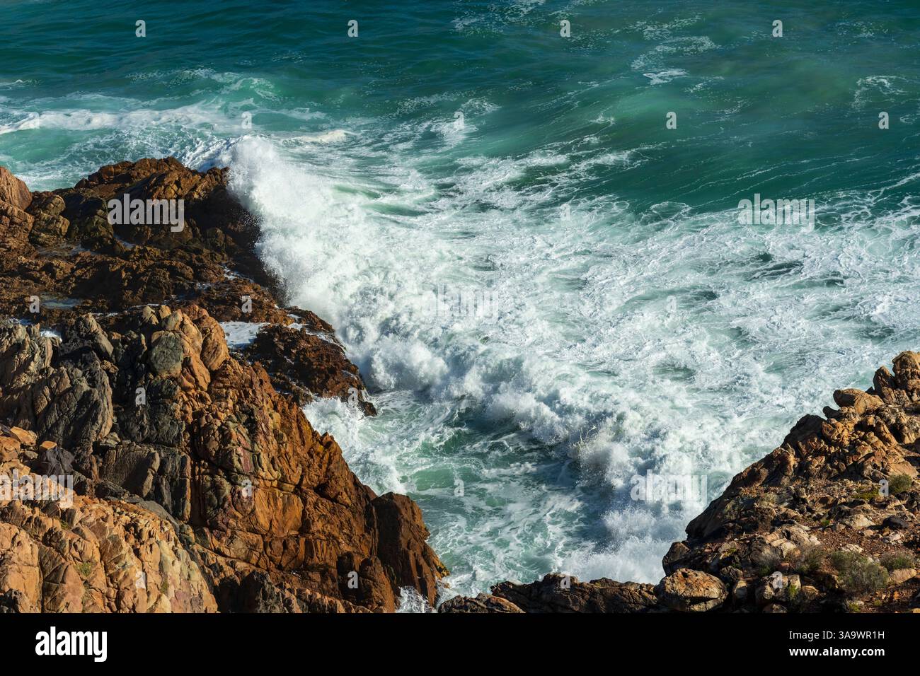Vue aérienne des vagues de l'océan se brisant sur le rivage rocheux accidenté le long de Clarence Drive entre Gordons Bay et Rooi-Els près du Cap, Western Cape Banque D'Images