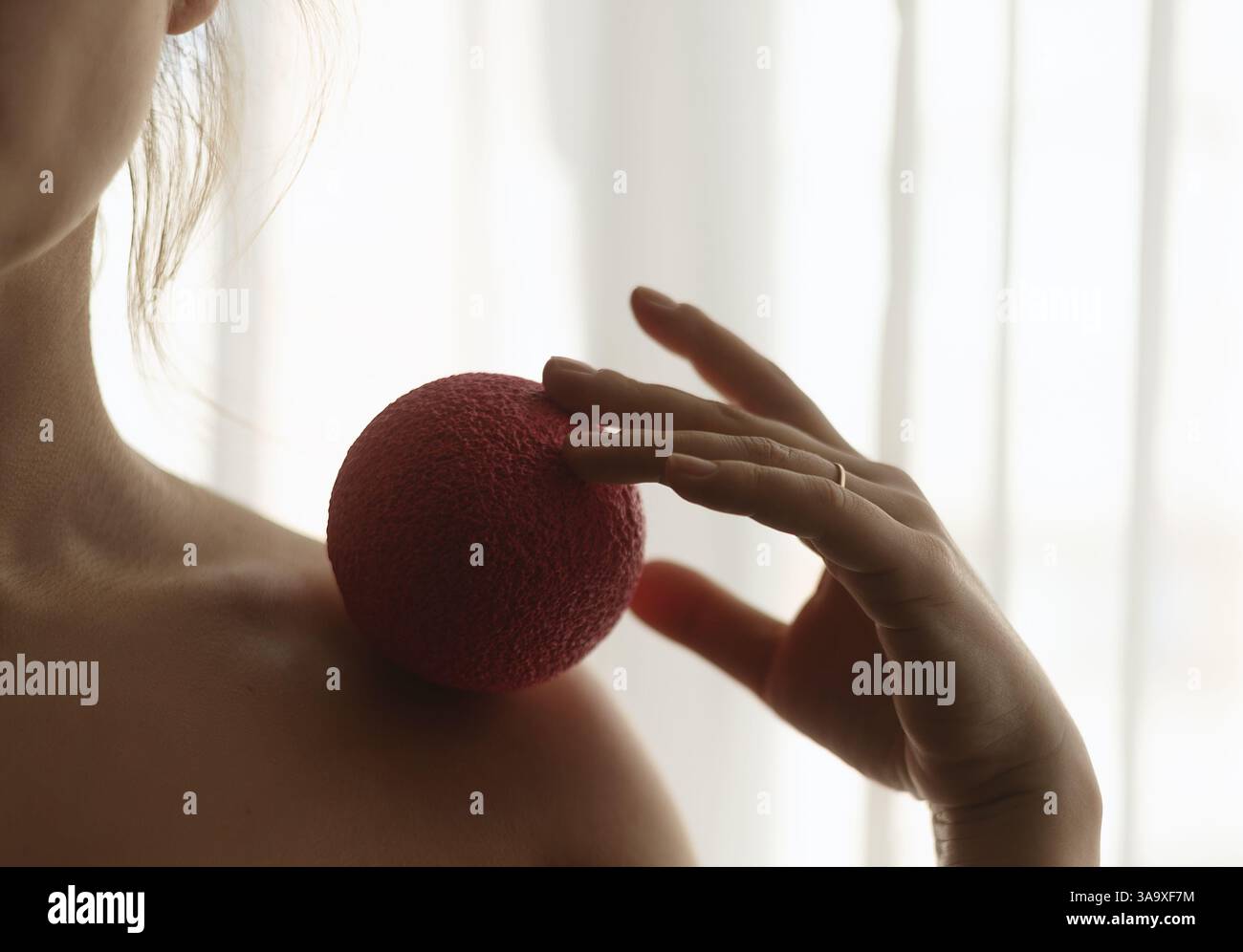 Gros plan de la femme roulant boule de massage sur les côtes avec la paume Banque D'Images