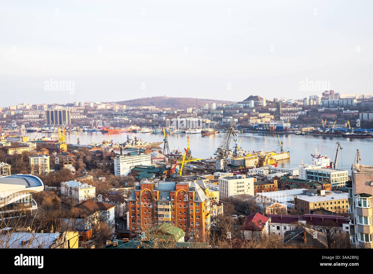 Port de fret dans la ville Vladivostok, détroit de la Corne d'Or. Ports commerciaux et de pêche, entreprises de réparation de navires dans la baie maritime. Bâtiments résidentiels le long de l'emba Banque D'Images