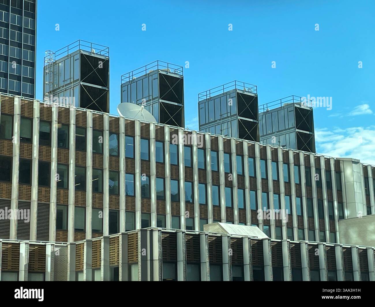 Un grand bâtiment commercial à Midtown Manhattan dispose de tours de refroidissement dans le cadre de son système de CVC, 2025, New York City, États-Unis - Image de stock capturée avec un smartphone