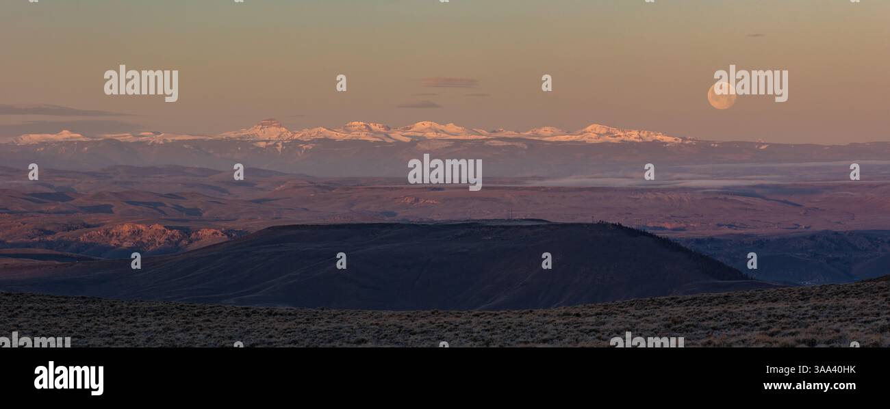 Une lune gibbbeuse décroissante est vue au lever du soleil sur Uncompahgre Peak et d'autres montagnes de San Juan couvertes de neige. Banque D'Images