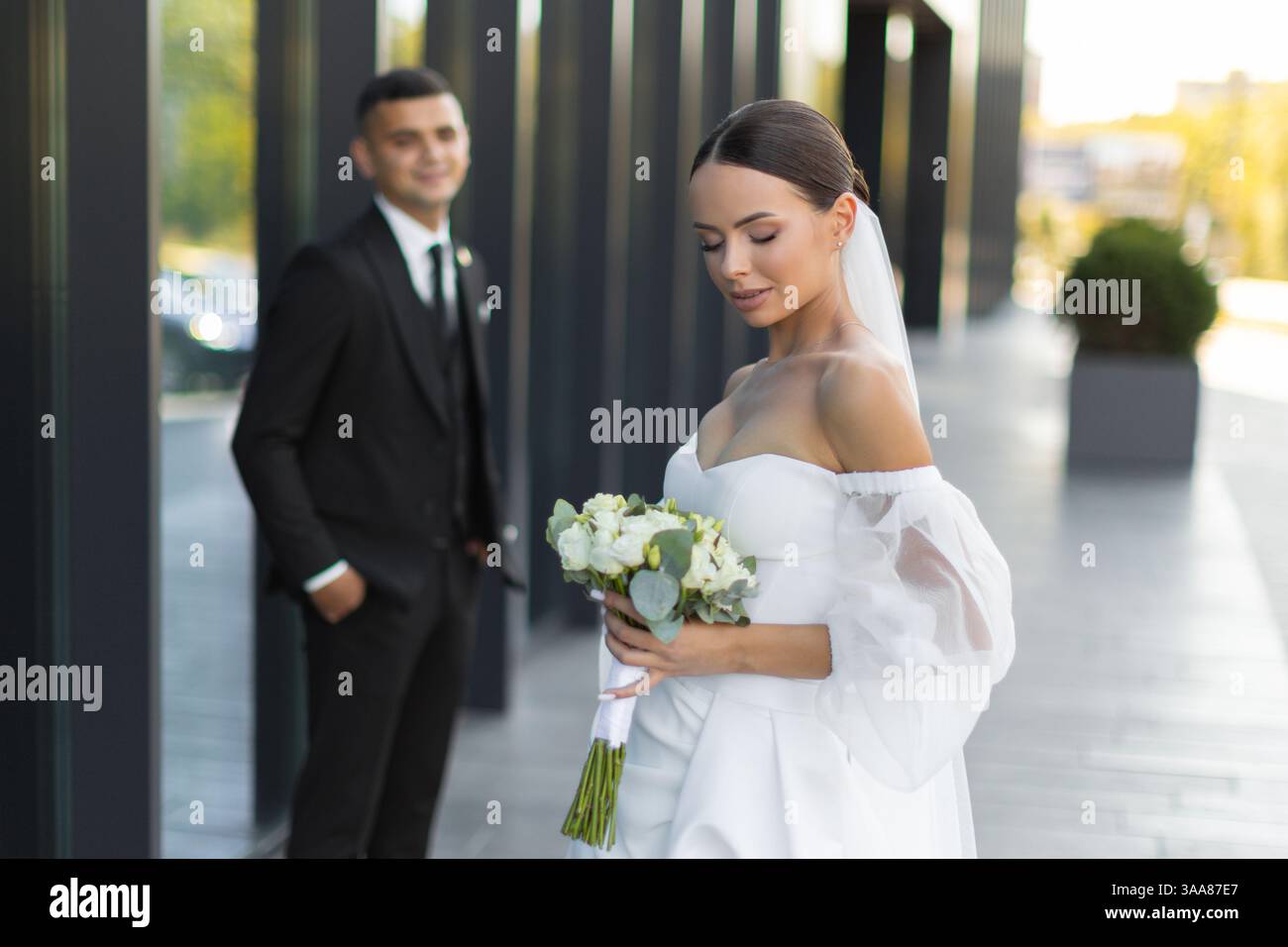 Couple de jeunes mariés célébrant leur mariage dans un cadre urbain, mettant en valeur l'amour et le bonheur lors de leur journée spéciale Banque D'Images