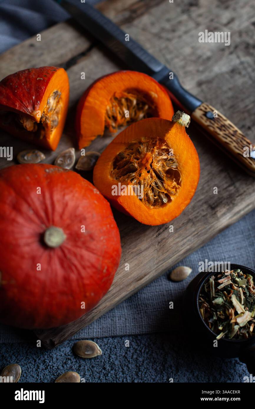 Citrouille orange, couteau et tranches de citrouille hachée sur la table. Capacité avec épices pour la cuisine maison Banque D'Images