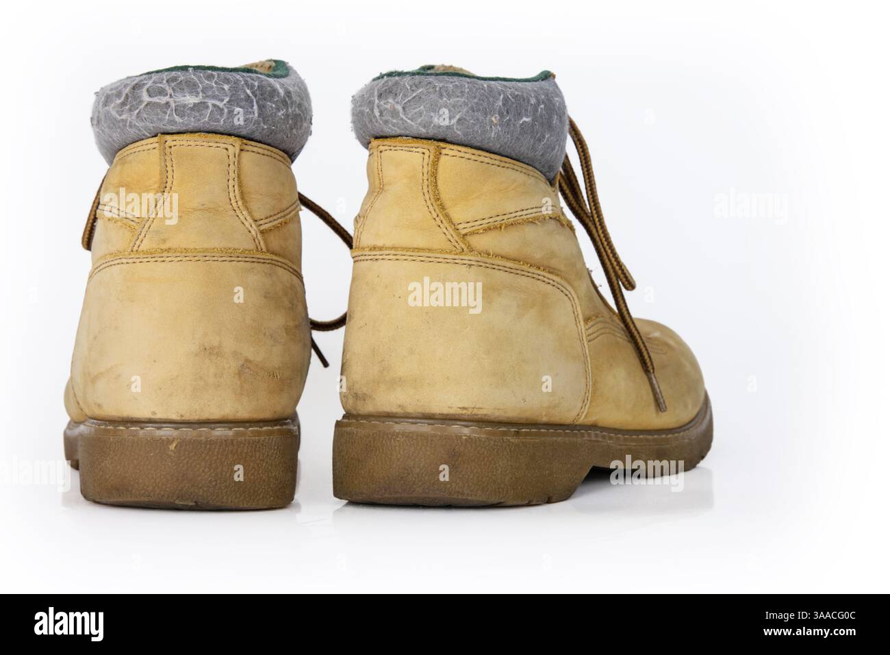 Bottes de randonnée en cuir jaune vintage avec lacets dans un look usé. Beige utilisé des chaussures militaires avec des semelles épaisses. Isolé sur fond blanc. Studio LIG Banque D'Images