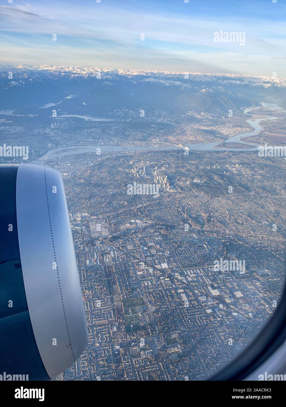 Vue rapprochée d'un moteur d'avion avec une zone urbaine dense ci-dessous, avec grille de ville détaillée et paysage. Banque D'Images