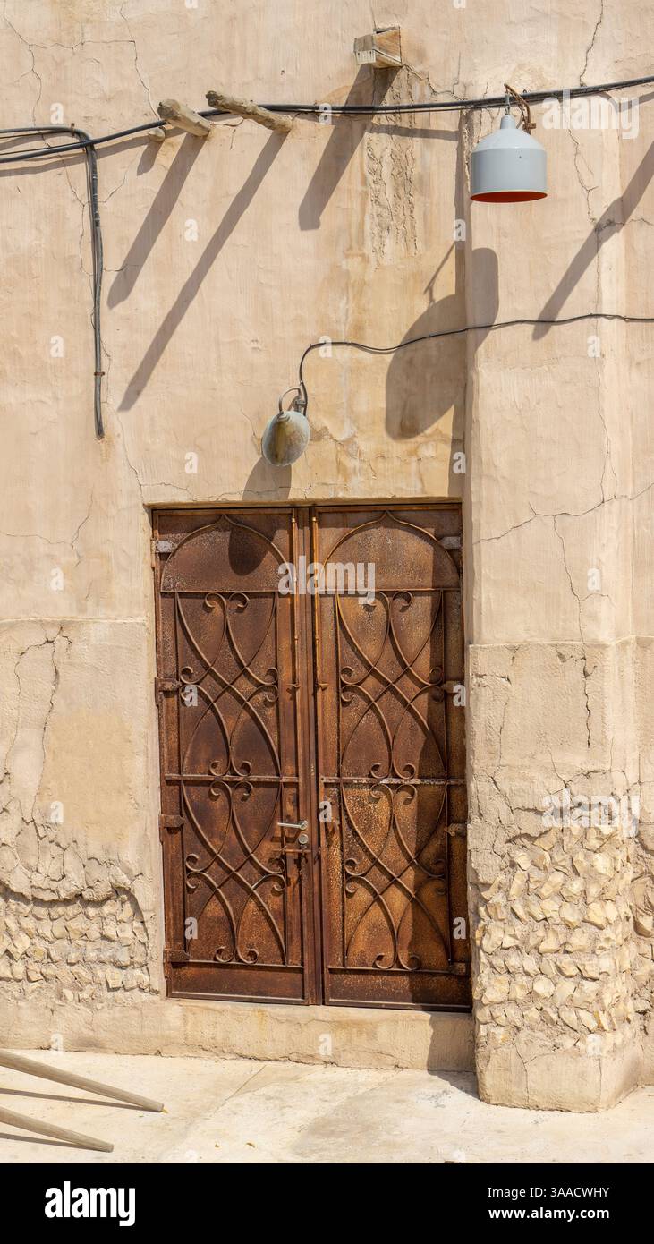 Porte brune en bois de bâtiment sur la rue de Dubaï vieille ville ou ville ou vieux village Al Seef Khor dans le quartier Al Fahidi, Émirats arabes Unis. Vertica Banque D'Images