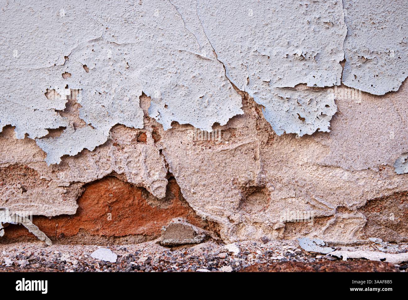 Mur altéré avec la peinture fissurée et écaillée détériorant le plâtre, exposant les vieilles briques, symbolisant la pourriture et le vieillissement. Copier l'espace Banque D'Images