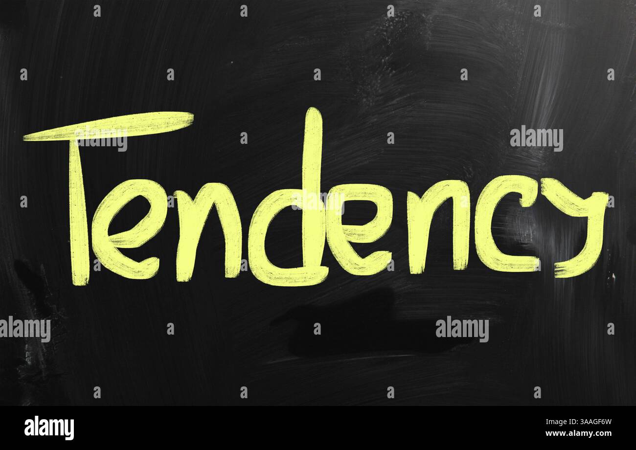 Tendance à la main avec craie blanche sur un tableau noir Banque D'Images