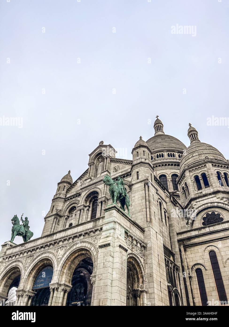 Photographie prise sur la colline de Montmartre à Paris, mettant en scène l'emblématique basilique du Sacré-Cœur. L'image capture l'atmosphère historique et artistique. - Image de stock capturée avec un smartphone