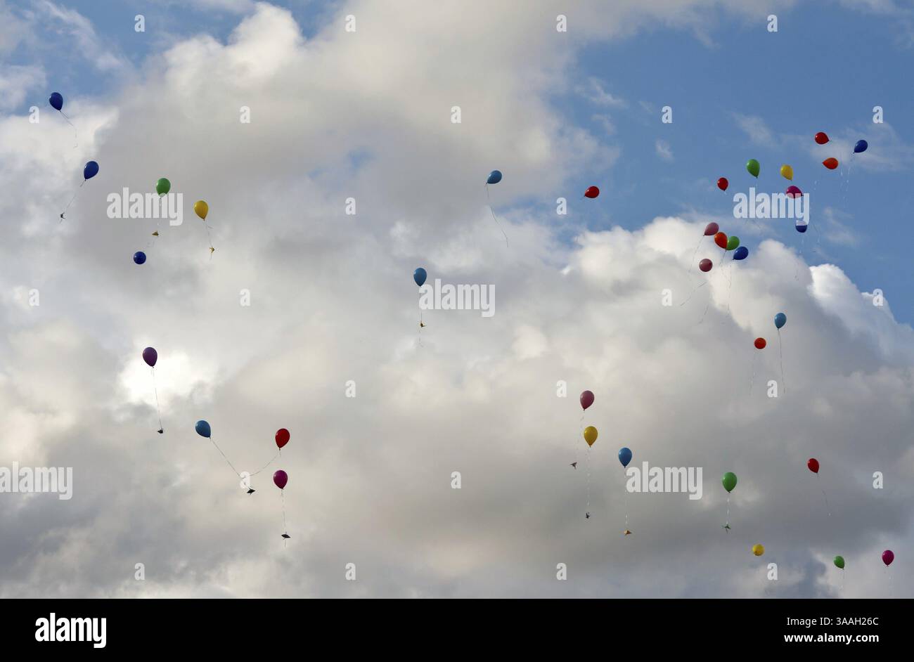Ballons colorés volant dans le ciel avec des nuages Banque D'Images