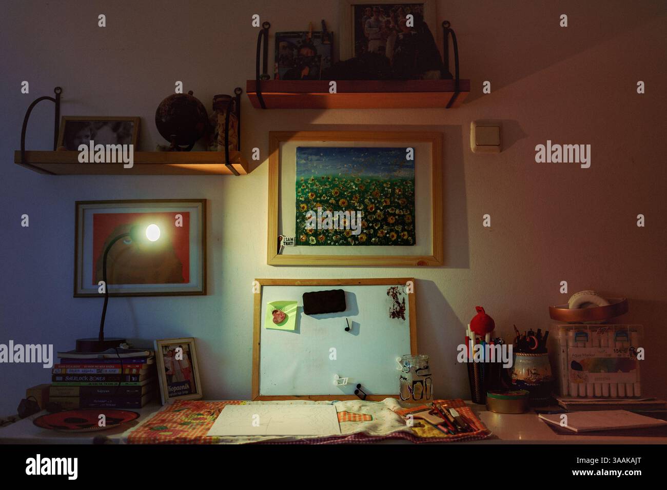 Cacak, Serbie - 26 février 2025 : Détails d'une chambre d'enfants, une table avec des fournitures de peinture, des photos de famille et des œuvres d'art pour enfants sur les étagères. Banque D'Images