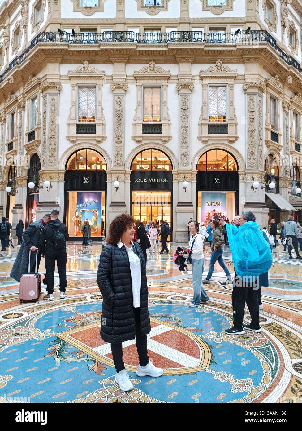 Italie Milan Piazza del Duomo : galerie marchande, Boutique Louis Vuitton, une touriste se fait photographier Banque D'Images