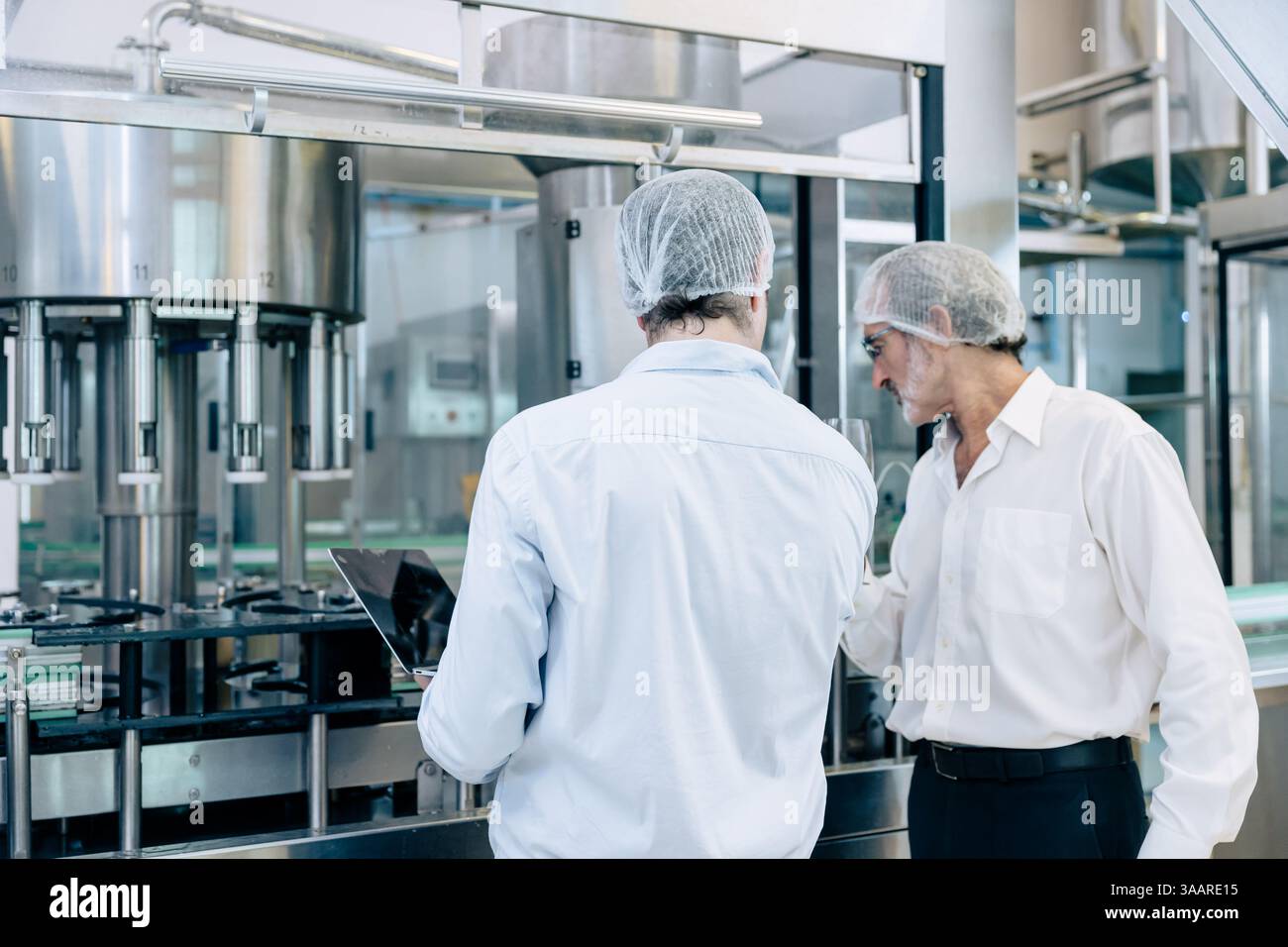 maintenance de service d'expert d'équipe de technicien d'ingénieur professionnel. homme vérifiant la machine dans la ligne de production d'usine de boisson pour certifier la norme de qualité Banque D'Images