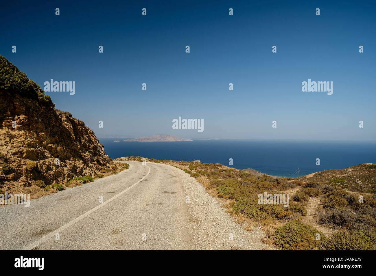 Vue d'une route solitaire et de la mer Égée en arrière-plan à iOS Grèce Banque D'Images