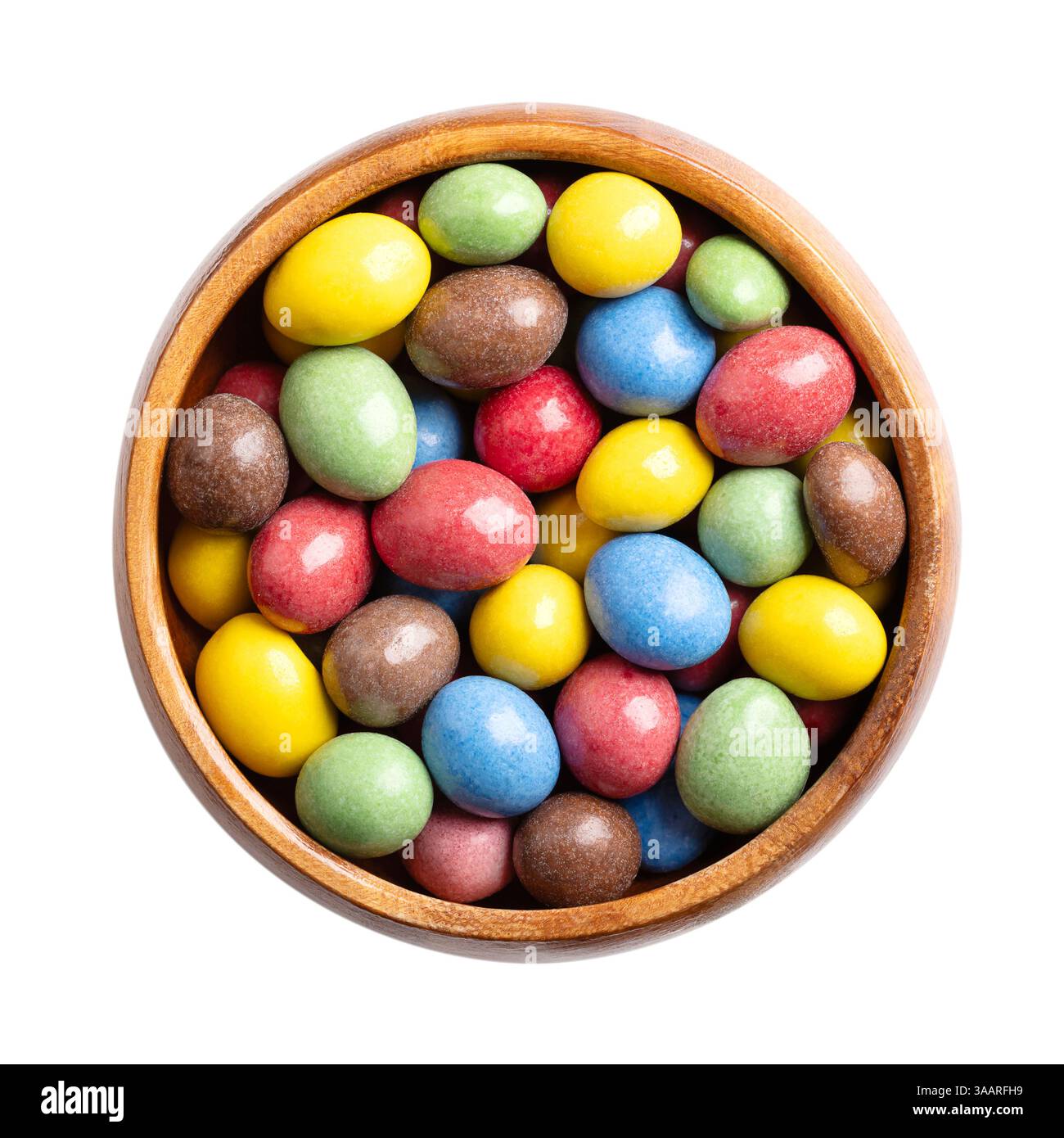 Cacahuètes au chocolat au lait enrobées de bonbons dans un bol en bois. Cacahuètes grillées, enrobées de chocolat au lait, enrobées de sucre multicolore. Banque D'Images