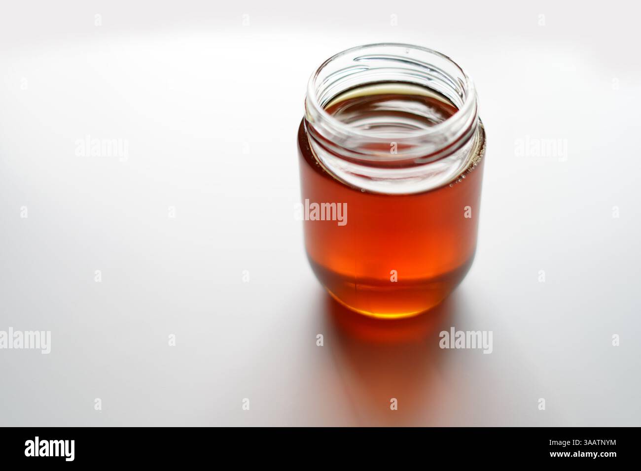 Pichet en verre Bee Honey sur la table blanche Banque D'Images