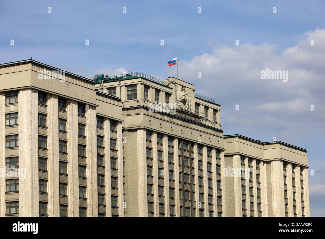 Drapeau russe sur le bâtiment du Parlement à Moscou contre le ciel bleu avec des nuages. Façade de la Douma d'État de Russie, autorité russe Banque D'Images