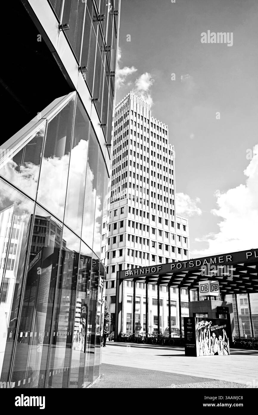 Potsdamer Platz point de rencontre animé à Berlin : architecture moderne, nuages reflétant la façade vitrée d'un bâtiment, entrée de la gare Banque D'Images