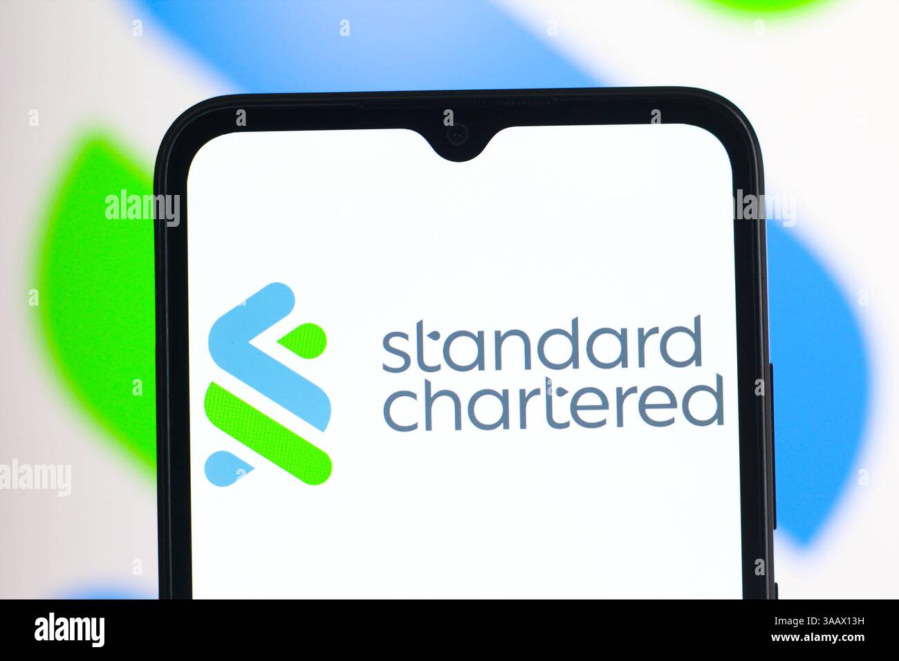 Dans cette illustration photo, le logo Standard Chartered est affiché sur l'écran d'un smartphone. Banque D'Images